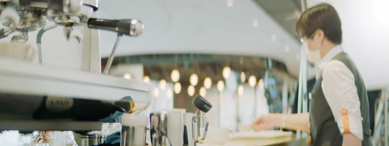 An employee walks behind the counter at a coffee house