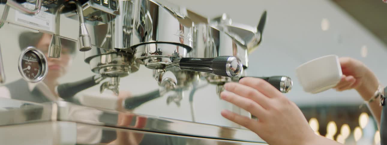 Barista preparing coffee in a espresso machine on a coffee shop