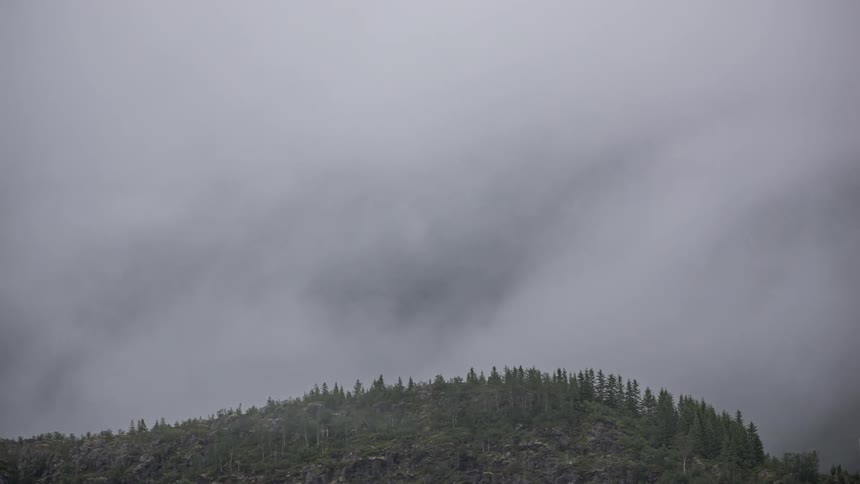 Fog dispersing to reveal a bigger green hillside