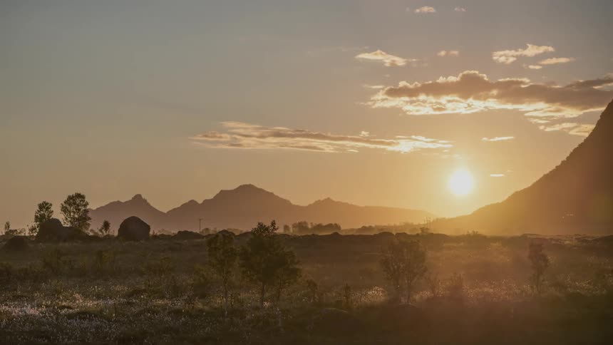 Timelapse of the midnight sun setting behind a mountain in Norway