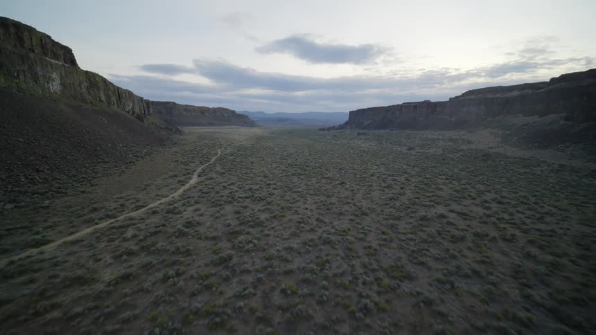 Pullback traverse over a desolate and arid desert valley surrounded by high plateaus