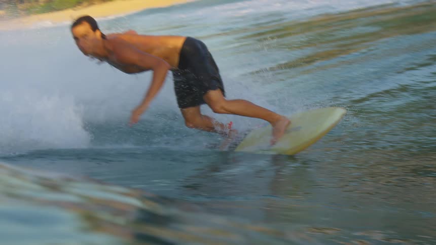 Man on a yellow surfboard riding a big wave in the ocean out during the day