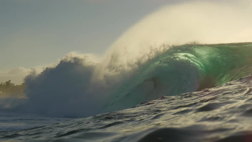 Huge wave rolls in splashing on a cloudy day