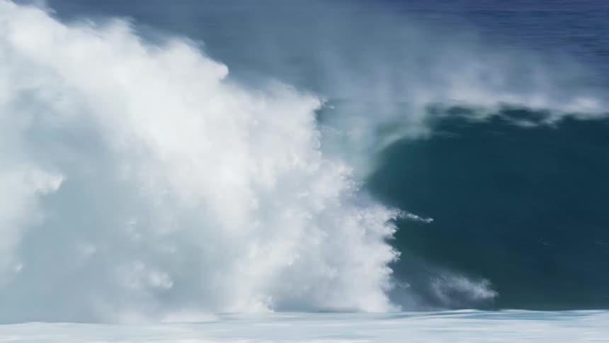 Male surfer rides a big wave on a red surfboard