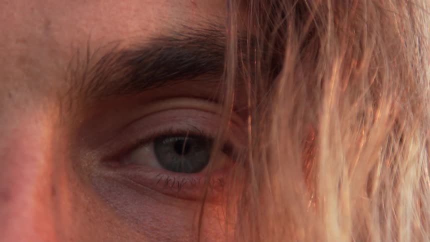 Blonde man with long hair opens his eye