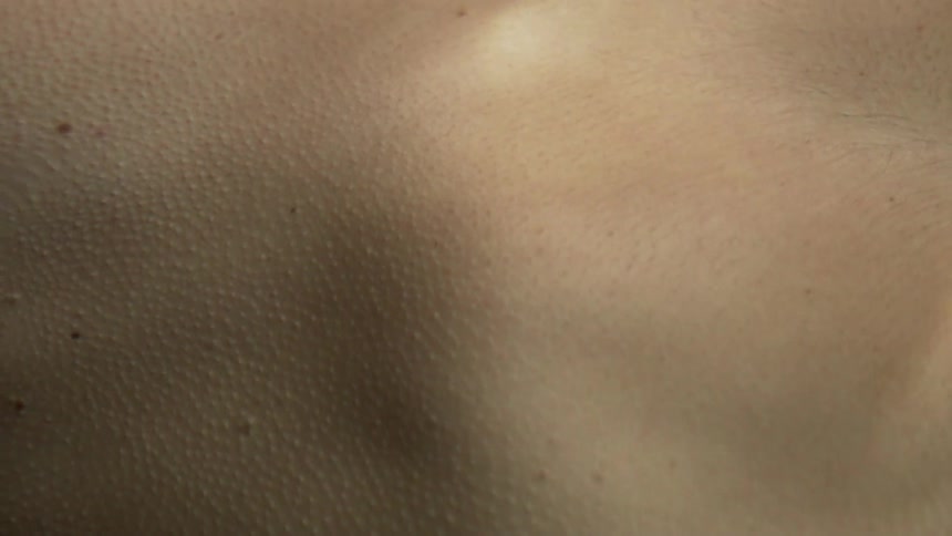 The skin of a person is covered in goosebumps as they are submerged in clear water