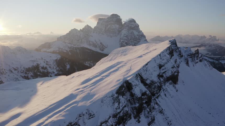 Mountain terrain peaks out from under a blanket of snow