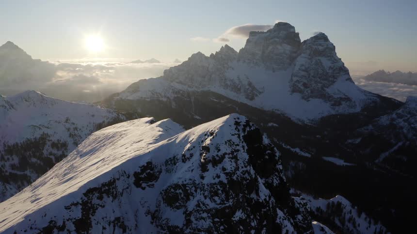 Snow covered mountains with high peaks at sunrise