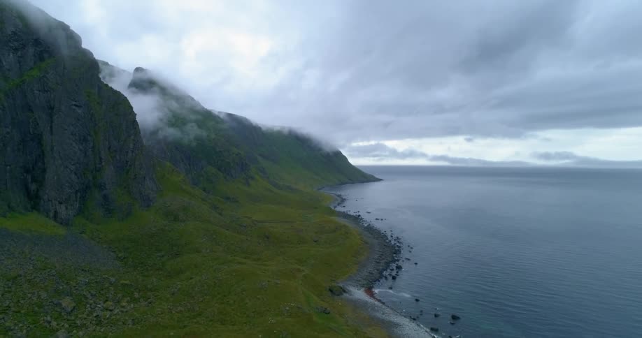 An aerial view of a lake with a mountain range on the coast