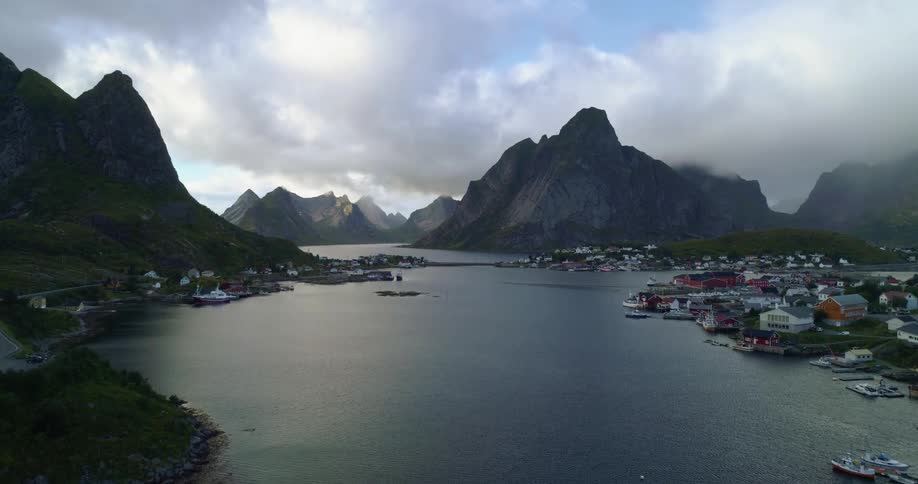 Aerial view of a body of water mountains and a small coastline town