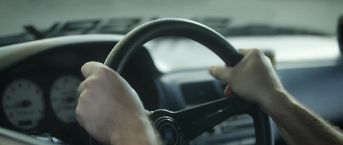 Mans hands grab the steering wheel