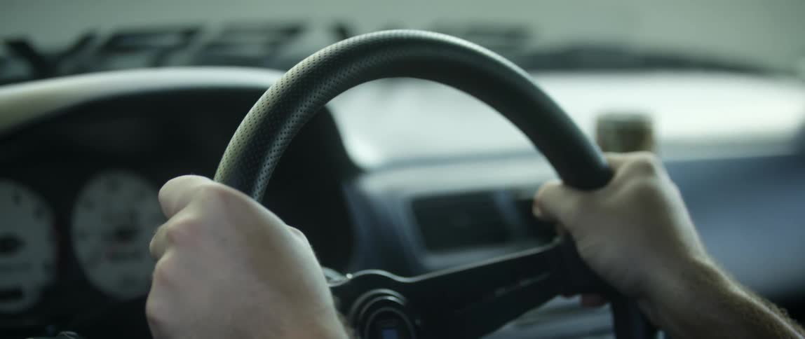 A persons hands grab the steering wheel