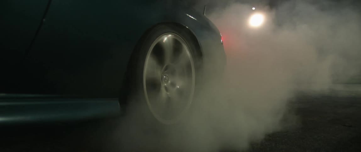 Heavy smoke rises from underneath a black vehicle that struggles to turn