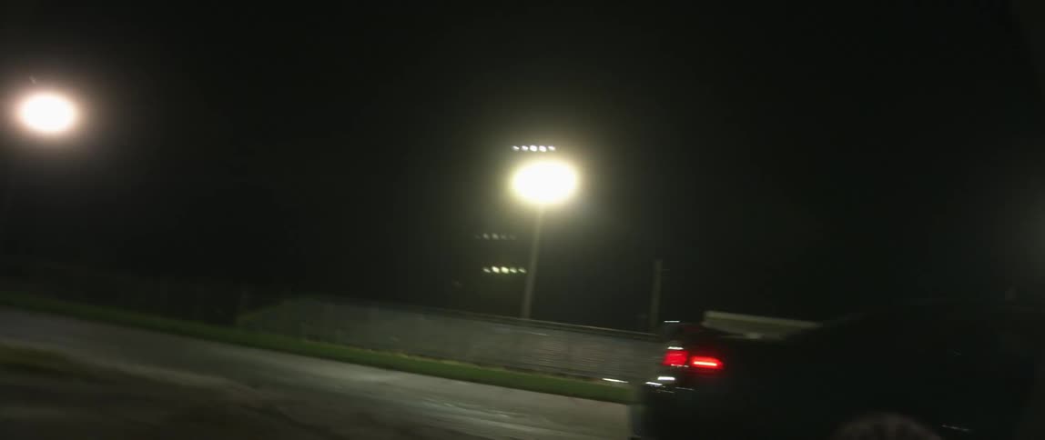 Sports car turns and spins on a race track at night