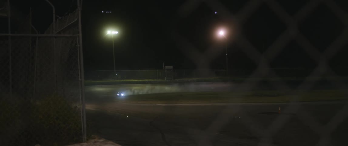 A car racing outside at night