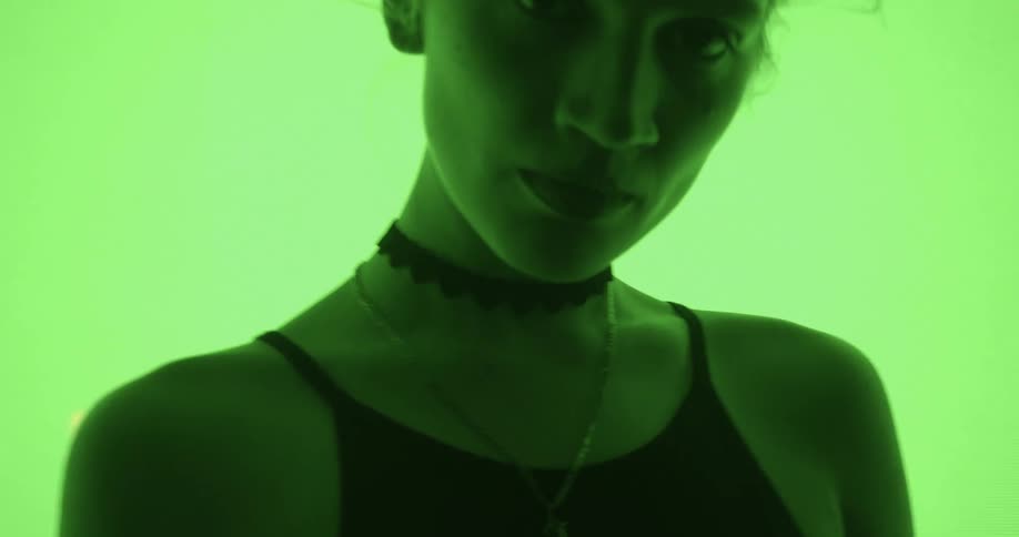 A woman with blonde hair stands in front of a large display flashing colors on it
