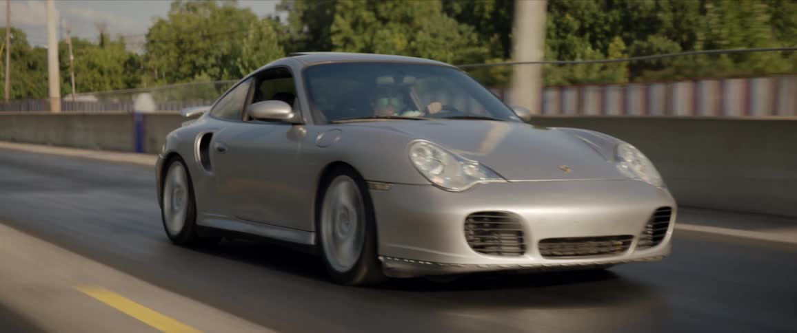 A man is driving a vehicle down a road