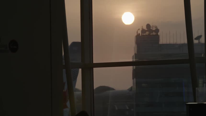A dawn or dusk sun above an airport