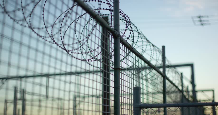 A barbed wire fence against a blue sky