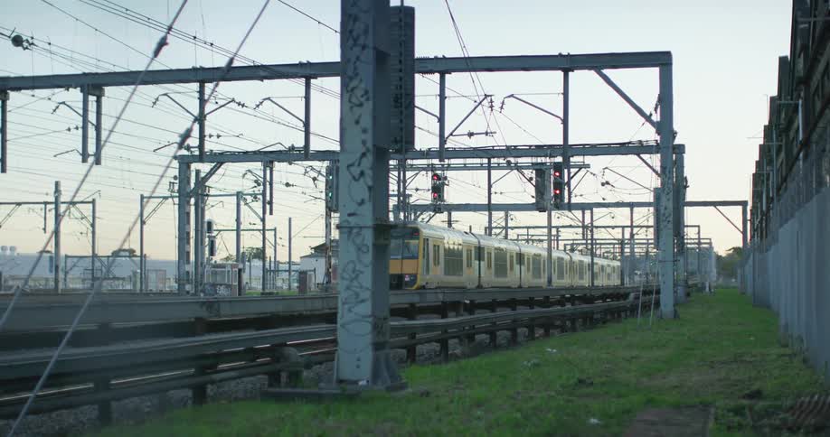 Passenger train moving by on a train track next to a strip of grass