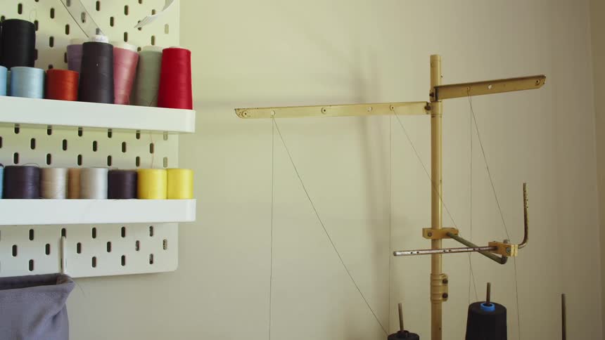 Spools of thread sitting on a wall shelf