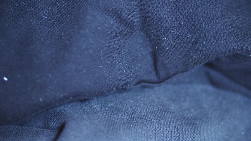 Extreme close up of the creases of a blue piece of clothing