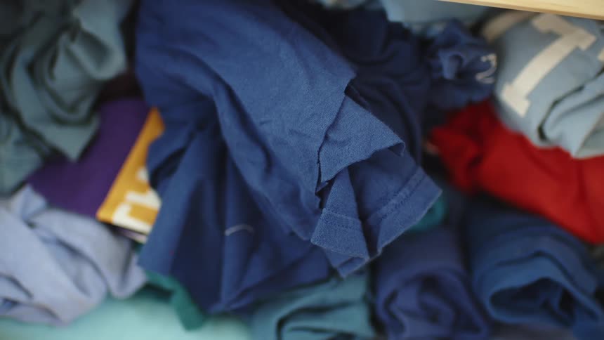 Different color shirts rolled up and stacked on top of each other