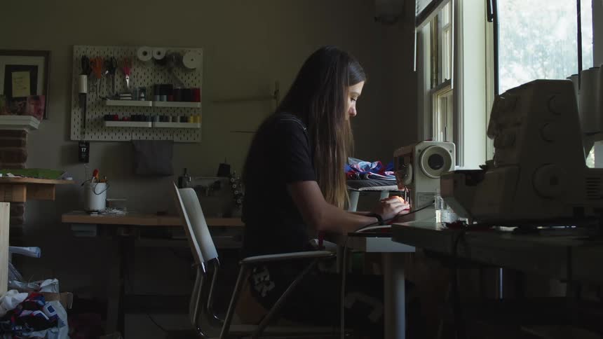 Young woman working on a sewing machine at home
