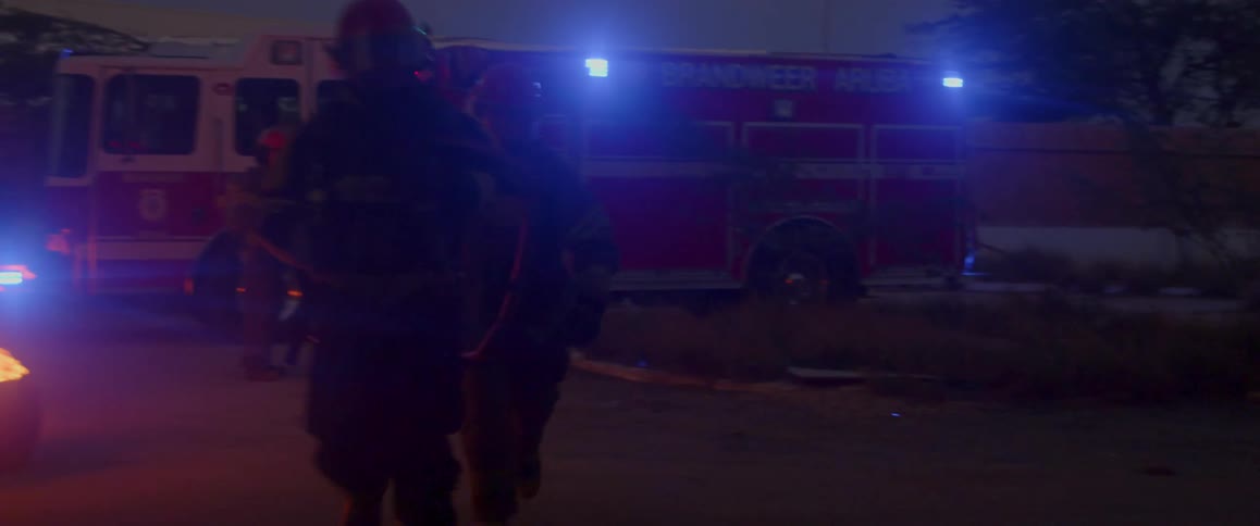 Firemen running away from fire truck and an object on fire