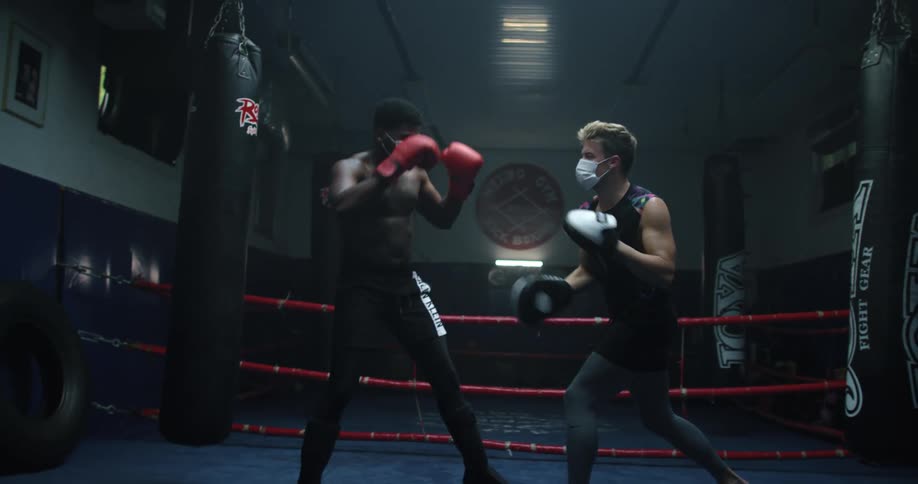 Two men boxing in a ring indoors