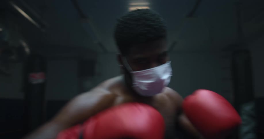 A man is boxing while wearing a mask
