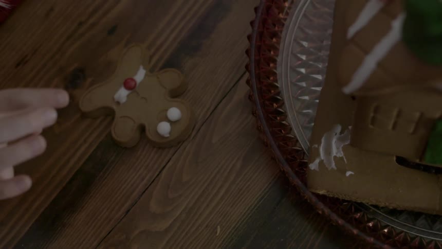 Someone decorating a gingerbread man cookie