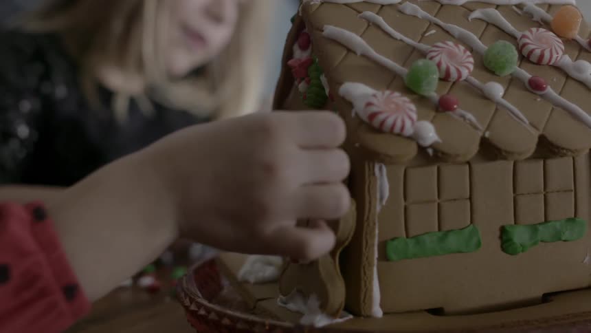 Children decorating a gingerbread house