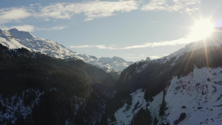 Aerial view of snow covered mountains at dusk are displayed