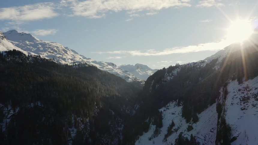 The sun is setting above the mountains