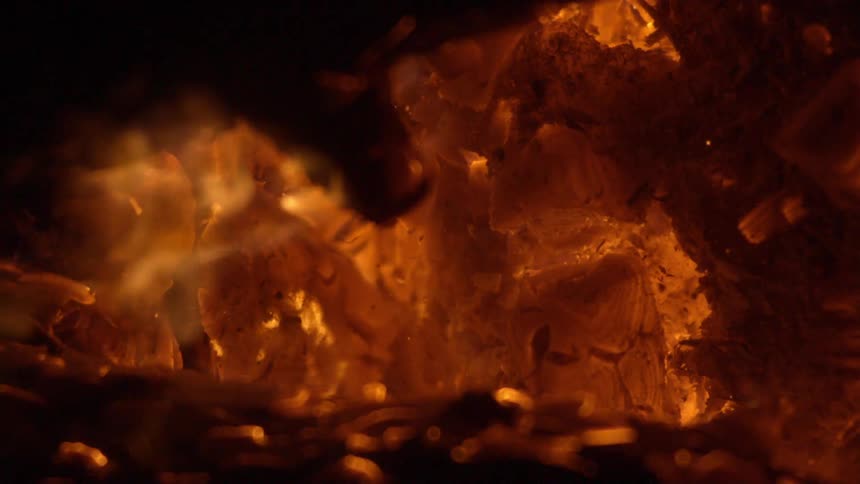 A fire is burning outdoors at night