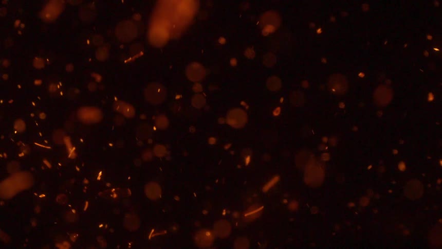 Fire embers floating through darkness