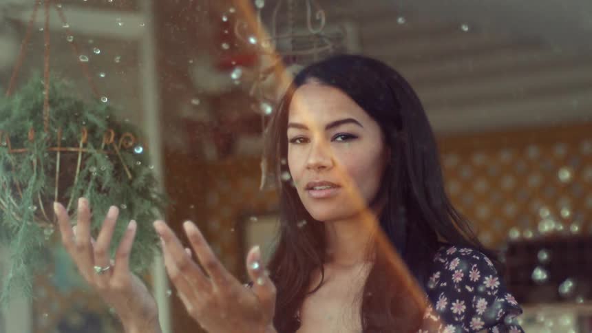 A woman holding her hands up to catch falling rain