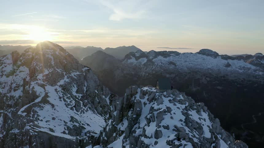 Aerial view of the sun setting over the mountains is displayed