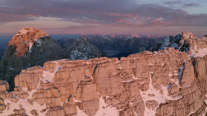 Two people standing on a cliff on a mountain