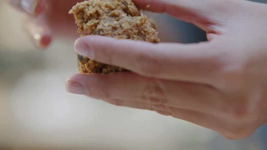 A woman shapes cookie dough in to a ball