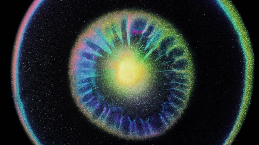 Black blue green and purple colors that look like a supernova exploding