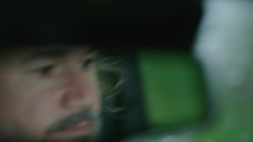 Rear view mirror reflection shot of a middle aged man anxiously storm chasing in rural united states with the threat of tornados everywhere