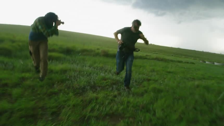 Two adventure photographers spring back towards shelter as they are slammed by large hail stones during a supercell storm event in Oklahoma