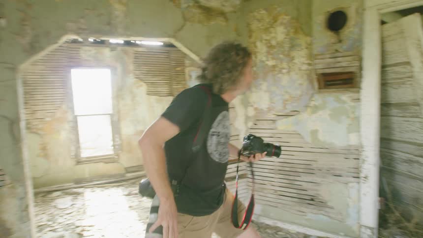 A storm chaser explores a beat up old house with in the mid west just before a super cell storm hit the area