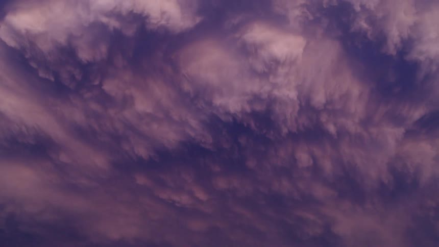 Time lapse of insane storm cloud textures as blue, purple and pink storm clouds collapse downwards at the end of a massive thunderstrom