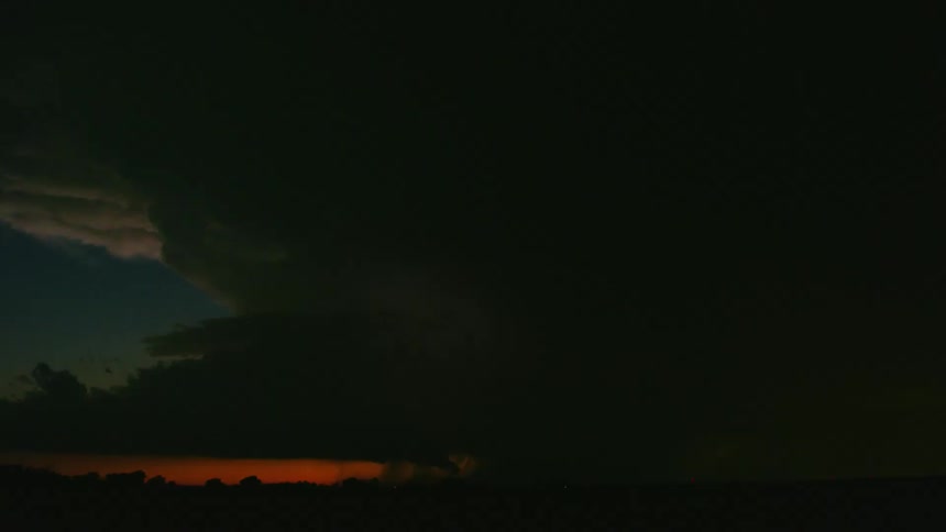 Awesome sunset timelapse of an intense and massive supercell thunderstorm cloudburst as massive amounts of rain are dropped and hundreds of lightning bolts flash