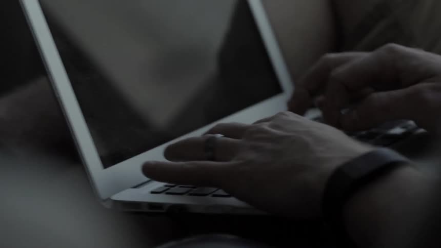 A man types on a laptop