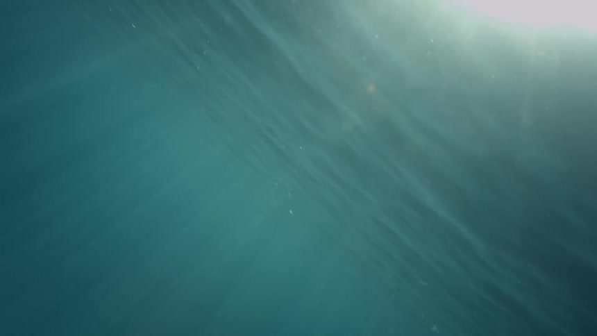Sunlight filtering through the surface of the clear blue waters of the ocean