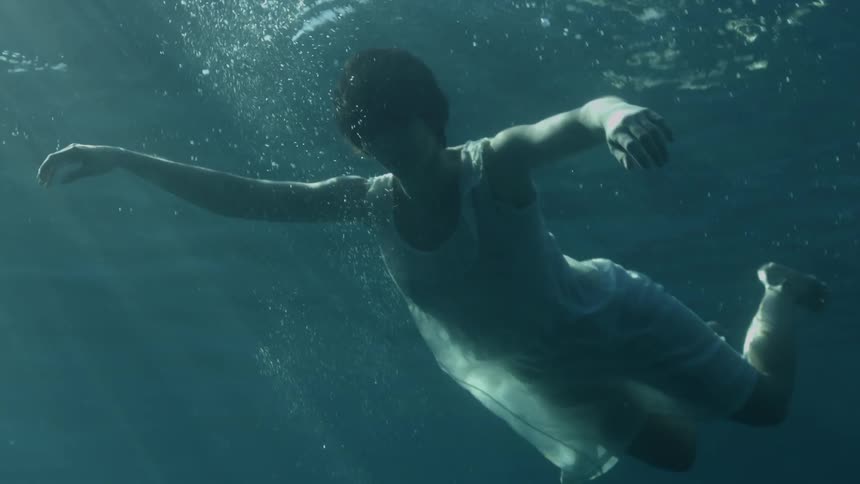 A woman is swimming under the water